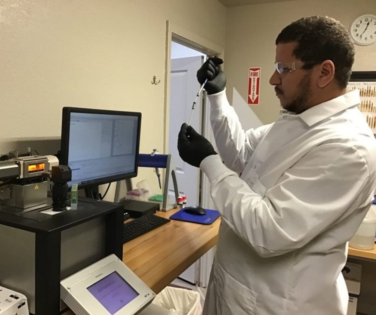 Technician in white coat working in the lab